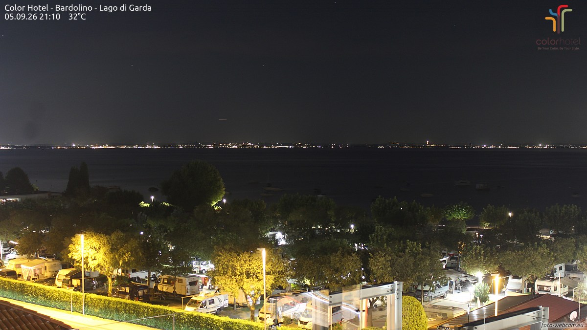 加尔达湖巴尔多利诺的湖岸夜景，对岸灯火成串，近处营地房车成排