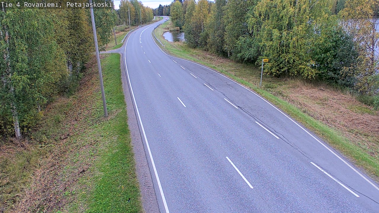 罗瓦涅米北极圈公路暮色：桦林泛黄，湿漉漉的路面与平静湖面
